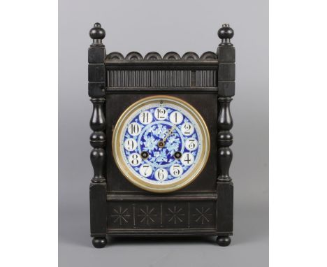 An antique French Aesthetic movement mantel clock by Samuel Marti, featuring an ebonised case with turned details, a blue ena