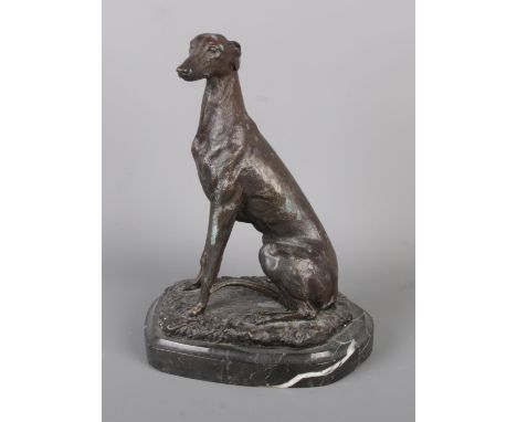 After JM Barrie, a bronze model of a seated greyhound on marble base. Signed Barrie. Height 19.5cm.
