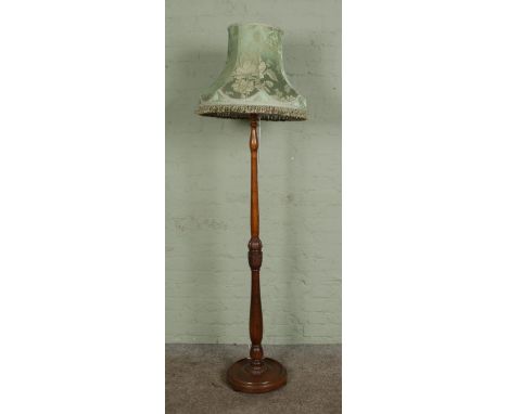 An oak turned and carved standard lamp with green shade