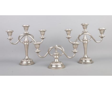 A pair of silver plated three branch candelabra, together with a small two branch centerpiece with central flame finial. Stam