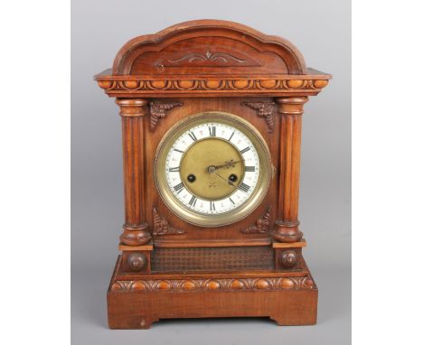 An antique German H.A.C 14 Day strike mantle clock, with carved case and column front, Roman numerals dial, pendulum present.