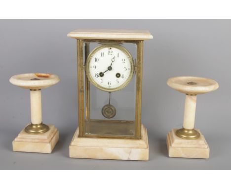 An antique Alabaster mantel clock garniture, comprising a rectangular glass-cased clock, with a Arabic numerals and pendulum 
