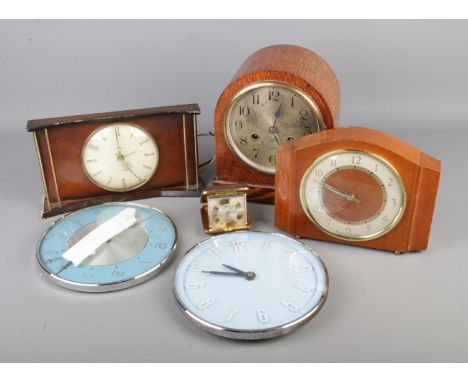 A box of clocks including Metamec wall clocks, Smiths mantel clock, oak cased mantel clock, Rythm travel alarm clock etc