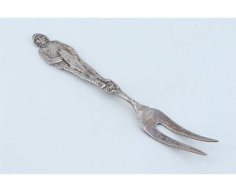 An early 20th Century 830 standard white metal two-pronged fork, its stem modelled as a fisherman holding his catch, stamped 