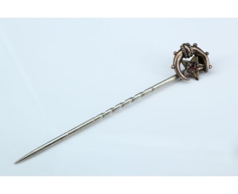 A Victorian stick pin, its terminal in the form of a star and crescent set with a pink stone and stamped "gold", 5 cm, termin