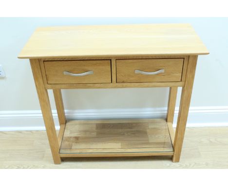 A contemporary oak side table, having a pair of drawers and glass-topped base shelf, 35 cm x 84 cm x 77 cm