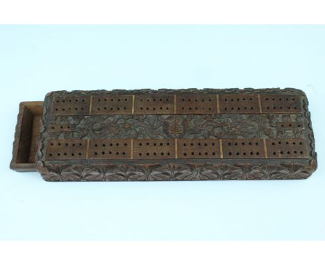 An early-to-mid 20th Century Chinese carved oak cribbage board, 30 cm