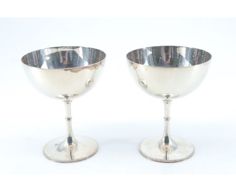 A pair of late Victorian silver wine cups, on slender stems, having a knop and beaded decoration, Sheffield, 1896, 228 g, 11 