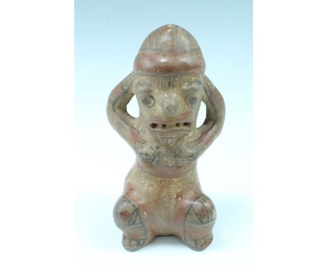 A South American ceramic figure, in the form of a squatting stylized female, painted terracotta, possibly pre-Columbian, 17 c