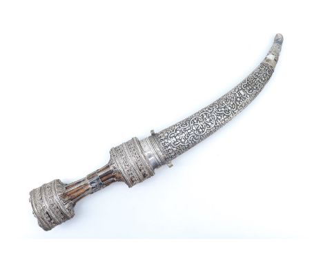 A fine late 19th / early 20th Century Middle Eastern jambiya dagger, the hilt bound in finely cannetille worked white metal, 