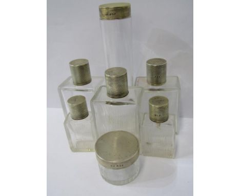 SET OF SILVER TOPPED PERFUME BOTTLES, 7 circular and square form glass jars with silver lids with engine turned decoration, L