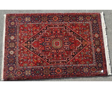 A vintage 20th century Persian Islamic Golthog carpet floor rug. Central diamond medallion, encapsulated in a red panel, repe