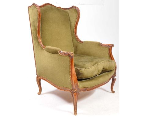 20th century French walnut show wood framed wingback armchair fauteuil. Raised on cabrile leg with scroll terminal feet havin