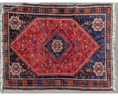 A vintage 20th century Persian Islamic Shiraz carpet floor rug. Having a central diamond medallion encapsulated in a blue pan