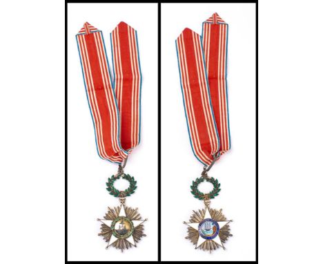 A Liberian Order of African Redemption sash and badge:  with white enamel five pointed star, the central device of a ship at 