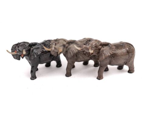 Three Beswick elephants: trunk stretching large, two under gloss, one under matt.