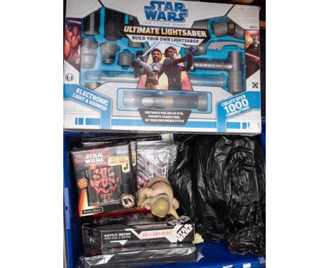 A collection of various Star Wars toys and collectibles: including The Clone Wars ultimate light saber.