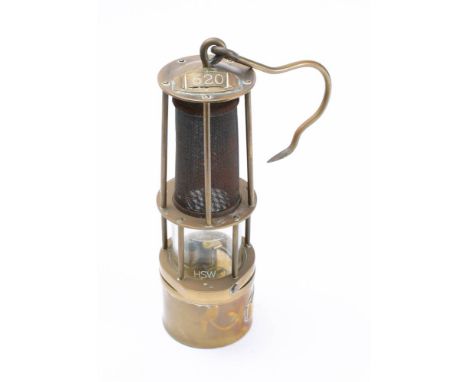 A brass miners lamp by KW: numbered '620' to  top and base and with folding flint lever to  bottom, 29cm high. 