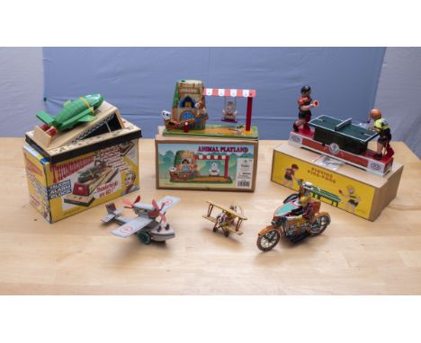 A collection of vintage clockwork tin toys and an alarm clock