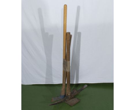 A pick axe and two other garden tools