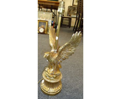 A cast gilt metal table lamp, modelled as the American Eagle, on a waited fluted plinth