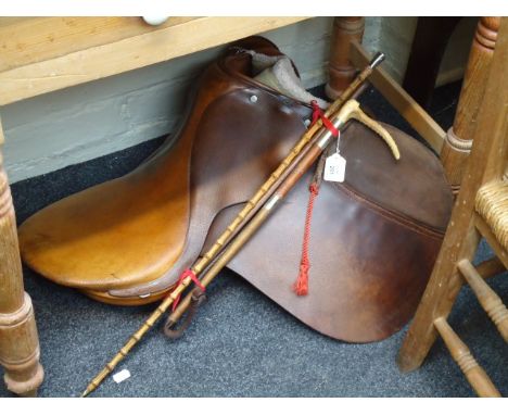 A general purpose leather saddle, with faux sheepskin numnah, a lady's hunting whip, a show cane and a silver mounted show ca