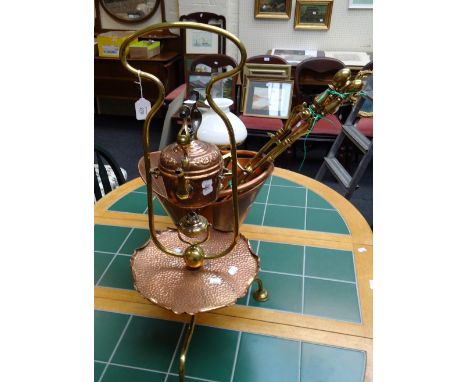 An Art Nouveau copper and brass spirit kettle, with an integral dished stand, a copper helmet shape coal scuttle, trivet, com