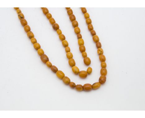 An Art Deco period amber bead necklace, the prehistoric toffee and caramel coloured oval beads ranging from 0.8cm to 1.5cm, 5
