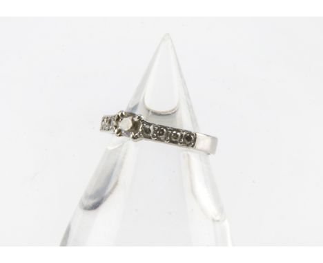 An Art Deco period platinum and diamond engagement ring, having an old cut to centre and four smaller examples to each should