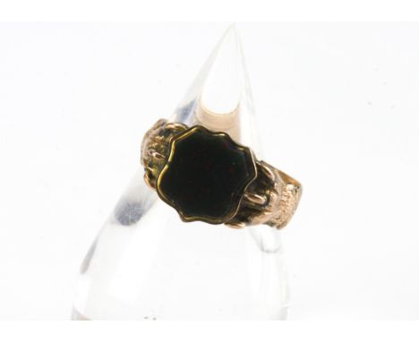 An early 20th Century gold and bloodstone signet ring, marked 14k, with lions paws holding a shield shaped tablet, 4.8g and s