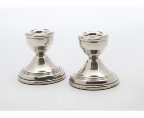 An Art Deco silver filled capstan inkwell, together with a pair of 1970s silver filled dwarf candle holders (3) 