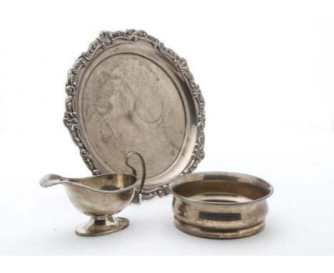 A late Victorian silver salver, together with an Art Deco silver wine bottle coaster and a similar period silver sauce boat (