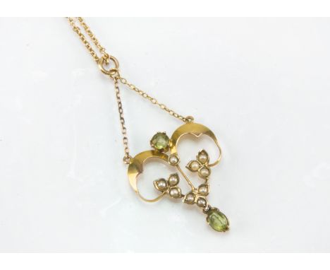 An Art Nouveau gold peridot and seed pearl pendant, supported on a fine chain, 4.4g, with a vintage W.Hinds box (2)light scra