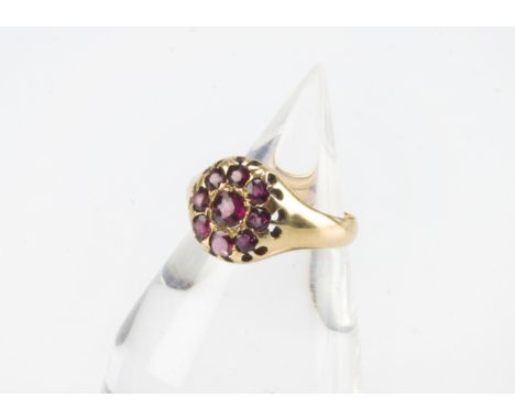 A late Victorian 18ct gold and ruby cluster ring, the round tablet set with synthetic rubies and one pink paste stone, 4.6g 