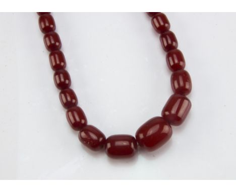 An Art Deco period cherry amber style necklace, the single string of ovoid beads measuring 2.6cm to 1.8cm, 69g 