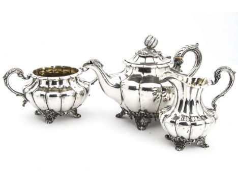 A William IV silver three piece tea set by RA WS, melon shaped with acanthus leaf handles, on scroll feet, teapot with ivory 