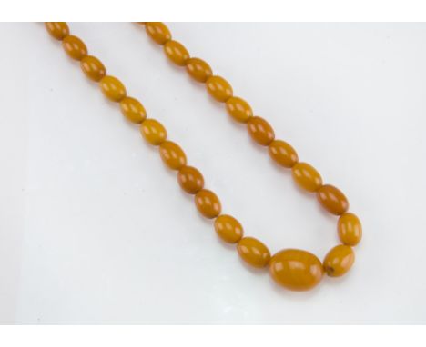 An Art Deco period amber bead necklace, oval toffee and caramel coloured prehistoric amber beads, largest 2cm, 29.4g 