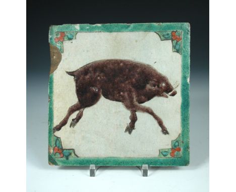 An Iznik tile, possibly 19th century Kutayha, painted in aubergine with a boar running against a white ground within a green 