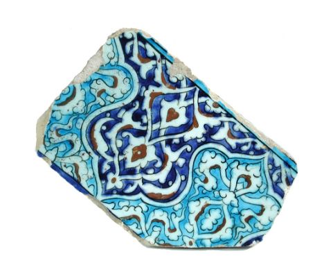 A 16th century Islamic Turkish Ottoman Iznik tile fragment painted with inverted ogee arabesque lobes interlocking in blue, t