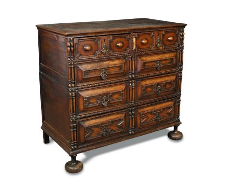 A 17th century oak chest of drawers, in two halves, geometrically moulded drawer fronts with brass drop handles, on later bun