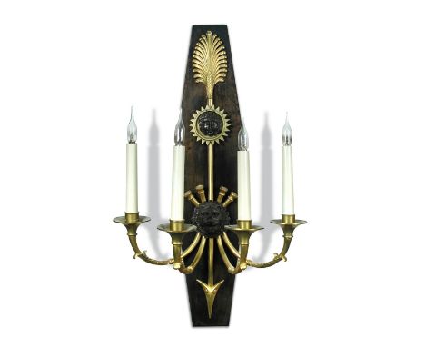Eleven Empire style bronzed and gilt brass wall lights by Phillips and Wood, the lozenge shaped backplates with applied arrow