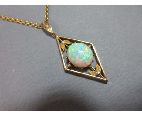 An opal pendant on chain, the oval cabochon opal with good play of colour, set in a open diaper mount with leaf and bead deco