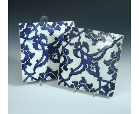 Two mid 16th century Iznik 'Dome of the Rock' tiles, each painted in blue on the diagonal with wing shaped leaves flanking bu