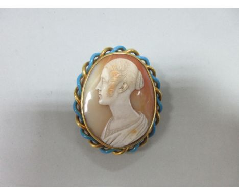 A portrait cameo of a young woman by Saulini set in an enamelled brooch, the finely carved shell cameo of a woman's profile w