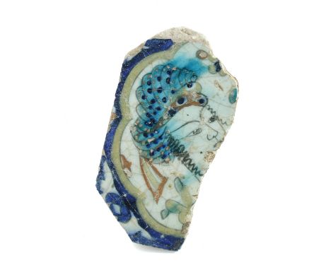 A 17th century Islamic Persian Safavid Kubachi tile fragment painted with a lady's head within wavy blue and yellow bands, he