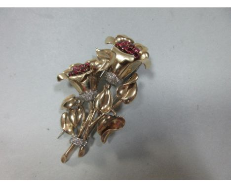 A ruby and diamond flower spray brooch, designed as two polished funnel form flowers set off with stems of heart shaped leave