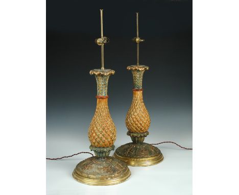 A pair of carved wood baluster pineapple lamps, the fruit between foliage bands and tinted in tones of red above the gilt cir