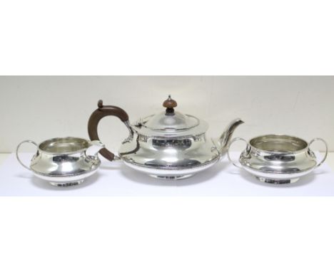 A silver three piece tea set, by Elkington & Co, Birmingham 1917, comprising:- a teapot of compressed circular shape with sca