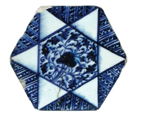 A 15th century Islamic Syrian Mamluk blue and white hexagonal tile, the central hexagon of flowers within a white six point s