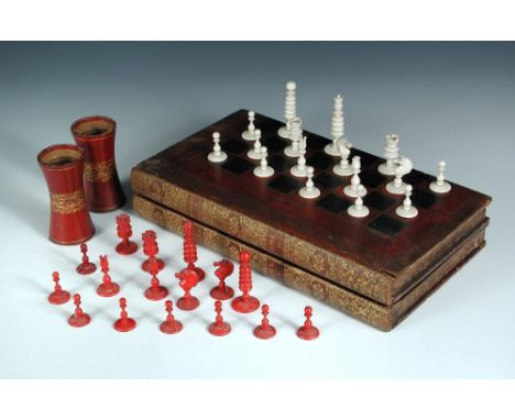 An Indian bone red and white chess set, leather mounted board and dice shakers, the set ring turned, the kings 6.5cm (2.5 in)